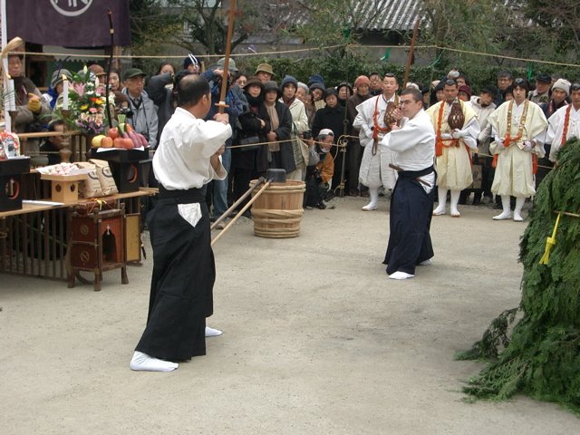 Practicantes que realizan una demostración de artes marciales japonesas tradicionales ante el público en una ceremonia al aire libre