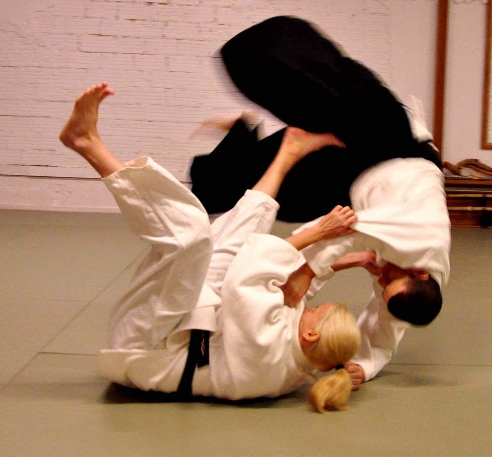 Práctica de jujutsu: dos practicantes con uniforme blanco realizan una técnica de proyección
